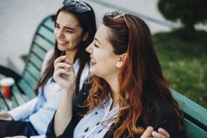 two women laughing and happy after learning about Rehab Admissions 