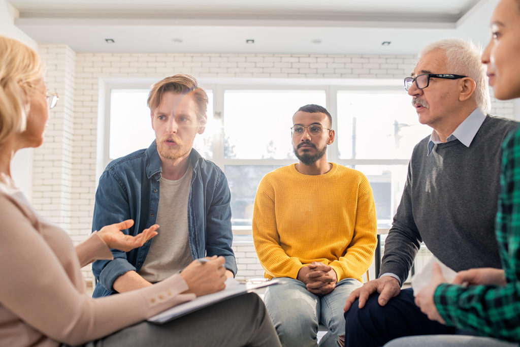 a group therapy session talking about inpatient vs outpatient rehab