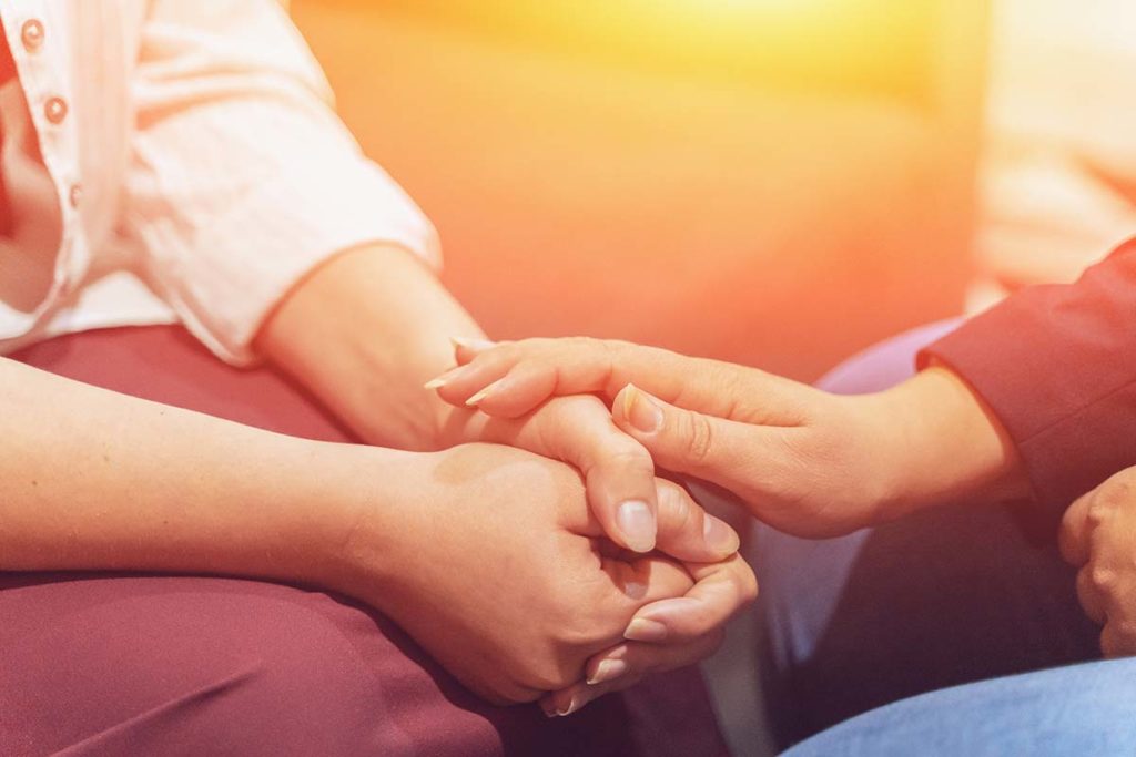 close up of friend placing hand on another's during national substance abuse prevention month