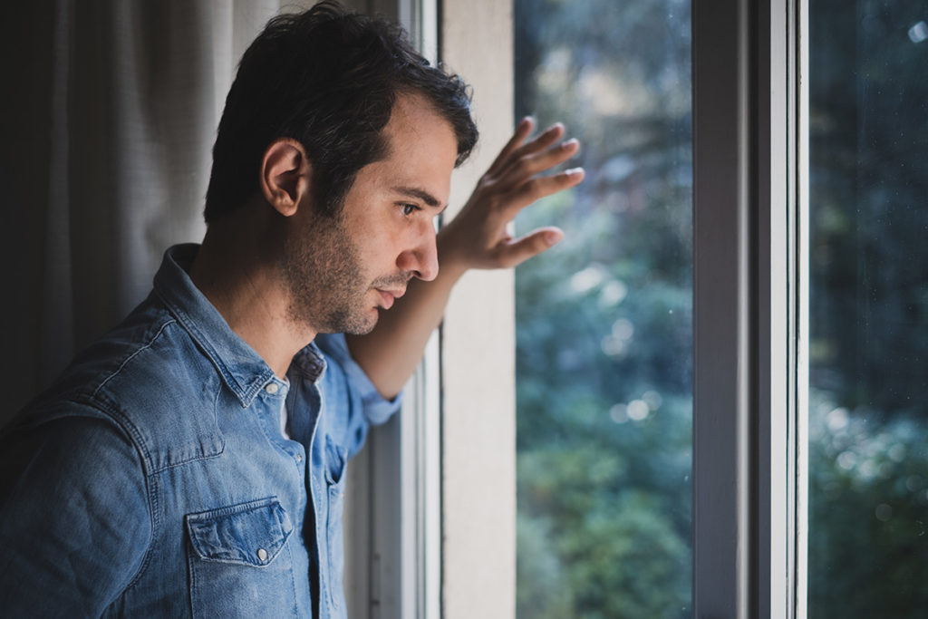 a man looking out the window wondering what the signs of a drug overdose are