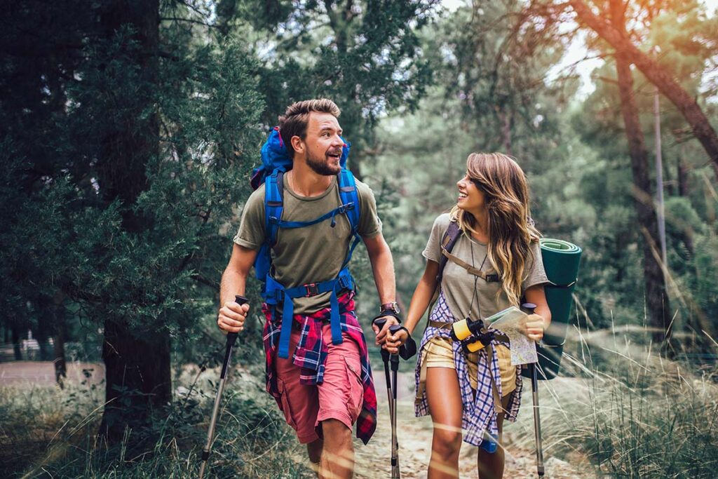 couple in recovery hiking through the woods enjoying fun sober activities for summer