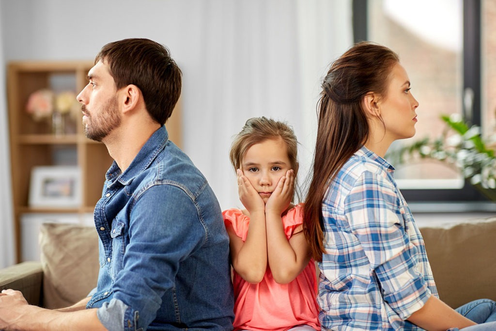 child between two parents with their backs to each other showing how addiction affects families