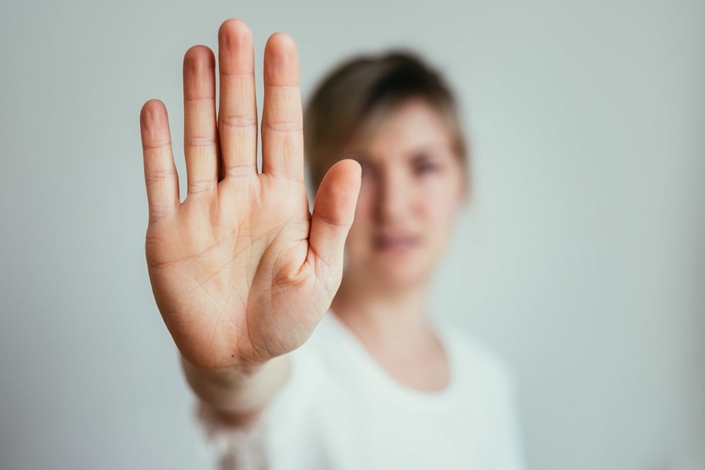 woman holding her hand up to show how to stop drug abuse
