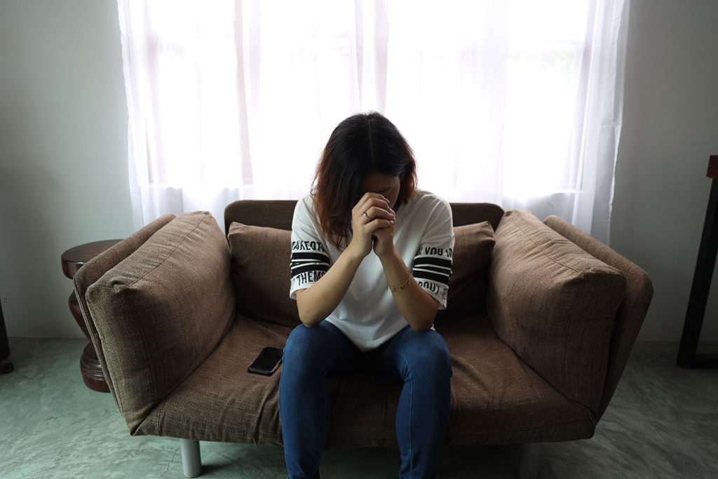 woman on couch considering the Risk of Alcohol Abuse