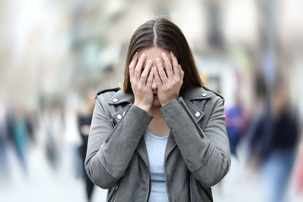 woman in crowd experiencing Triggers of An Anxiety Attack