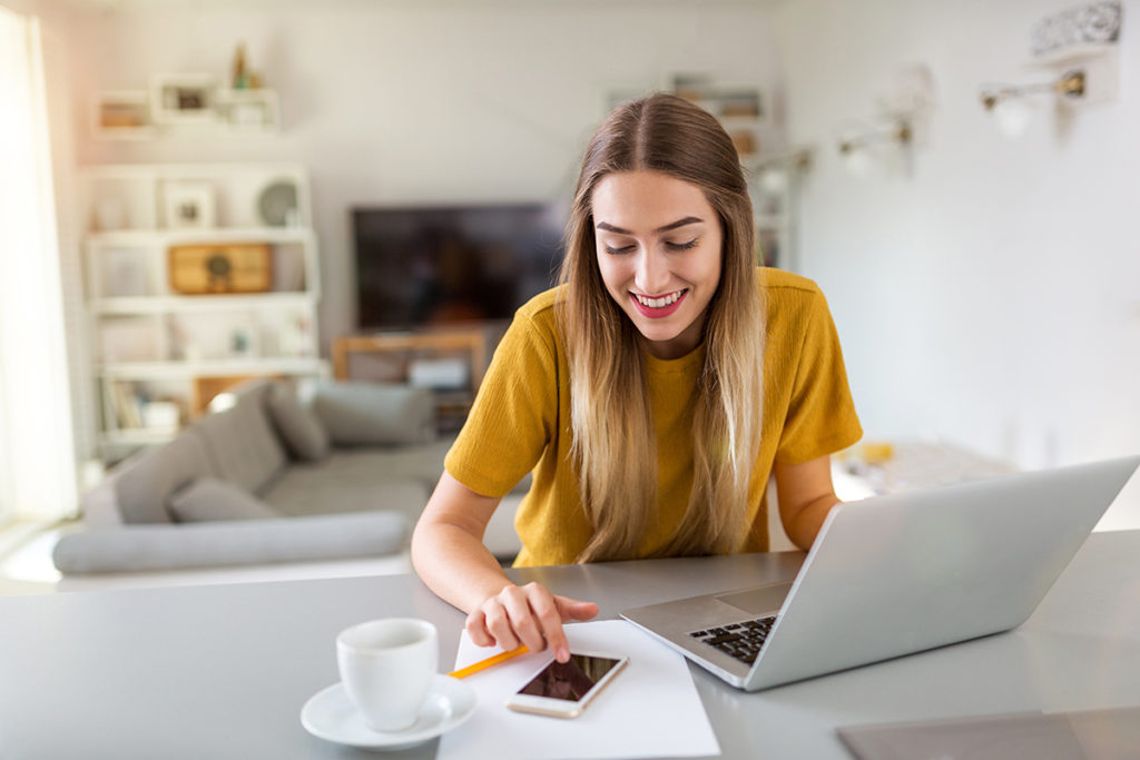 woman on laptop and phone Coping with Loneliness During Quarantine