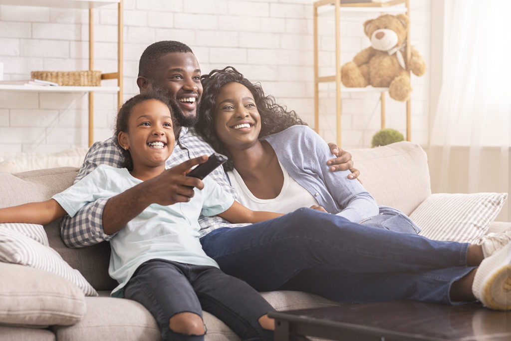 family hugging couch watching tv knowing How to Fill Your Time Sober in Quarantine