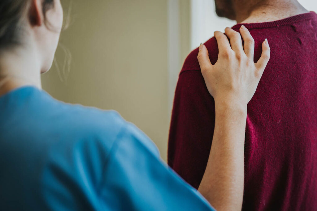 a concerned friend laying their hand on the shoulder of a person and asking are you ready to get addiction help