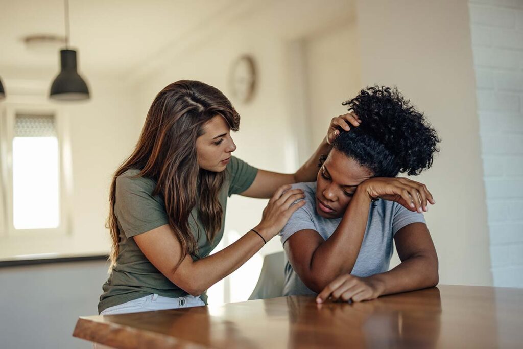 compassionate woman consoling younger woman as she explains what are the emotional and physical effects of dependency