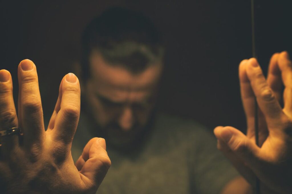 Man with hands on mirror, struggling with popper addiction