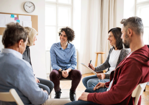 People sitting in a circle at a group therapy program