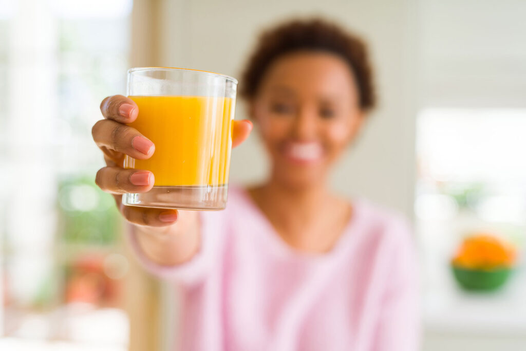 person in withdrawal and orange juice in a glass she's holding