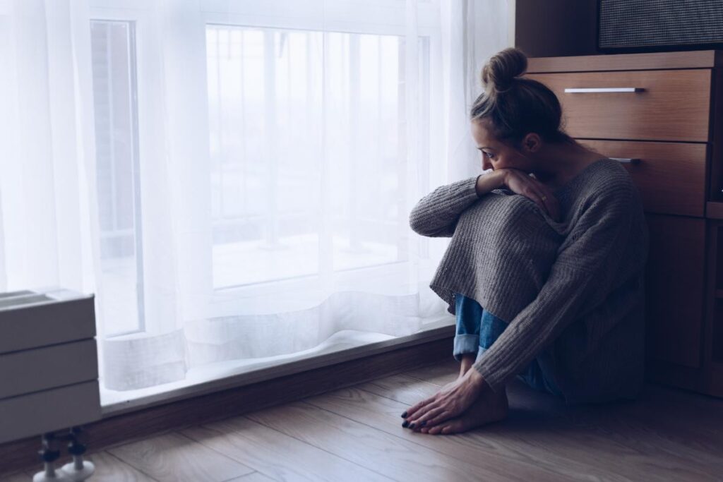 Person thinking about their problems with alcohol and anxiety while looking out window