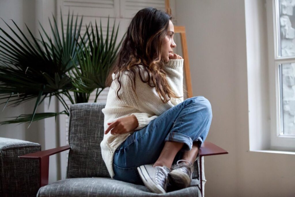 Person looking out window and feeling the effects of smoking marijuana and anxiety symptoms simultaneously
